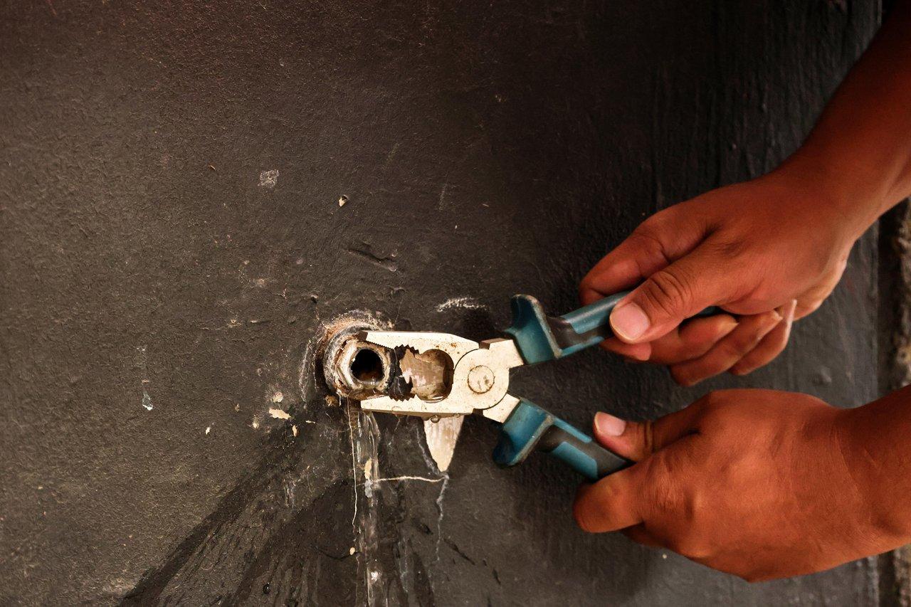 Intervention technique d'un plombier lors d'une réparation urgente de plomberie pour une gestion locative efficace aux Abrets.