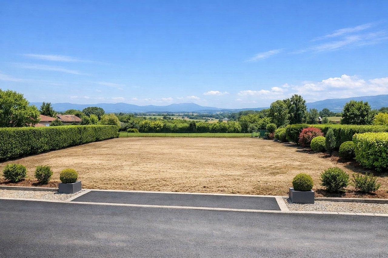 Terrain constructible plat aux Abrets-en-Dauphiné avec vue dégagée et accès goudronné, cadre calme et lumineux.